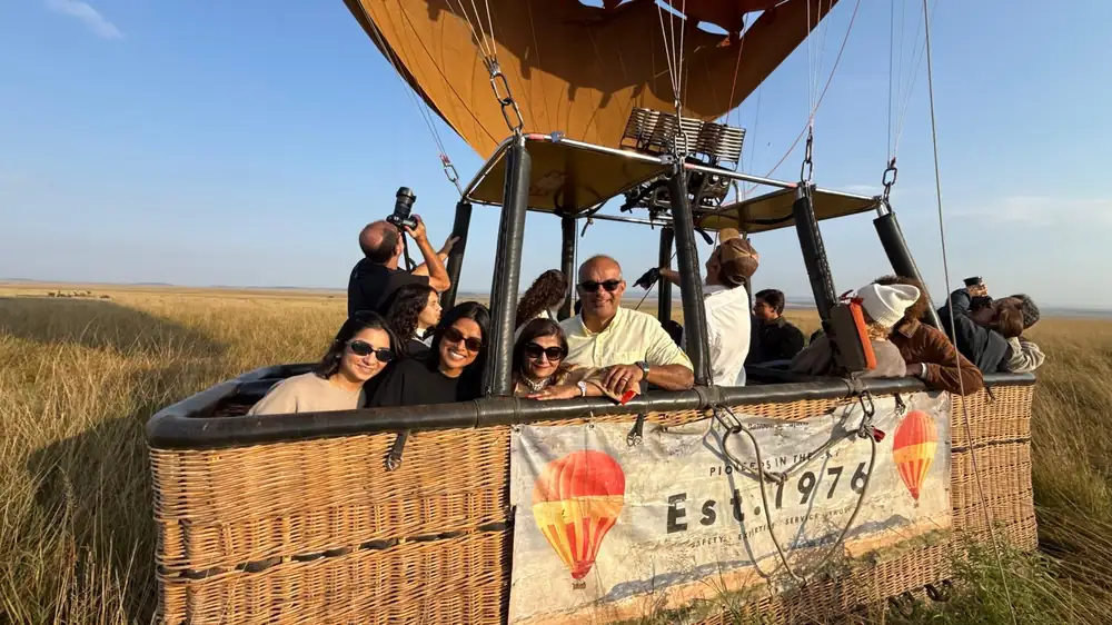 Travelers celebrating from a hot air balloon over the African savanna